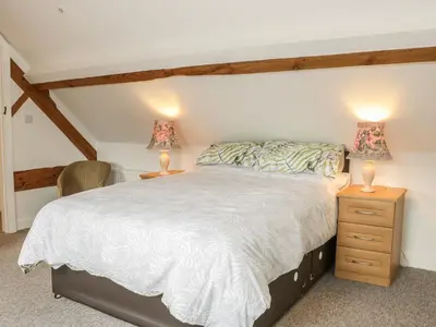 a bedroom with a bed and two lamps on tables at The Cow Byre, Heath Farm in Clee Saint Margaret