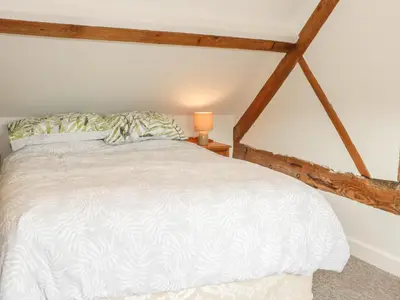 a bedroom with a white bed and a lamp at The Cow Byre, Heath Farm in Clee Saint Margaret