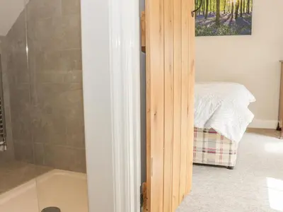 a bathroom with a shower and a bath tub at The Cow Byre, Heath Farm in Clee Saint Margaret