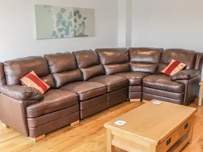a brown leather couch in a living room with a coffee table at The Cow Byre, Heath Farm in Clee Saint Margaret
