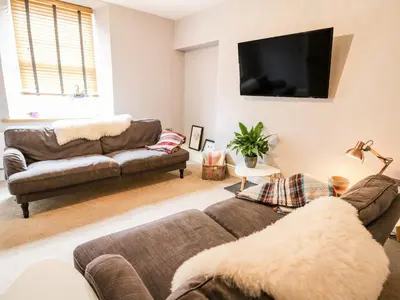 a living room with two couches and a flat screen tv at Water Street in Aberaeron