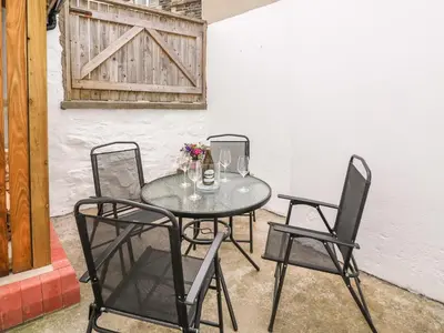 a table with two chairs and a table with flowers on it at Water Street in Aberaeron