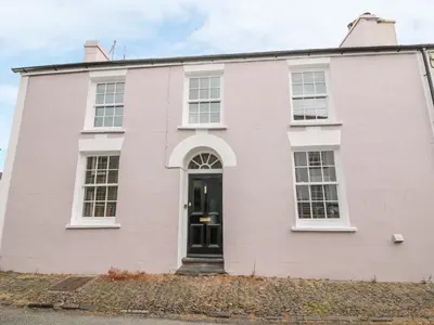a white house with a black door at Water Street in Aberaeron