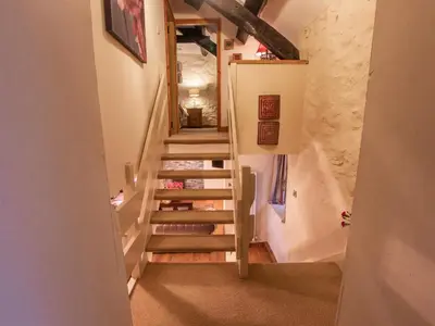 a winding staircase in a home with white walls at Cefn Uchaf Cottage in Llanbedr