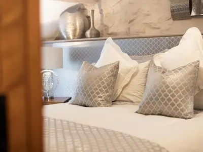 a bedroom with a bed with pillows and a headboard at Cefn Uchaf Cottage in Llanbedr