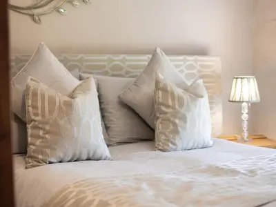 a white bed with four pillows on top of it at Cefn Uchaf Cottage in Llanbedr