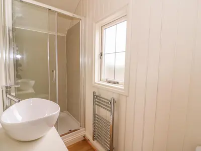 a white bathroom with a sink and a window at Hillside View in Saint Harmon