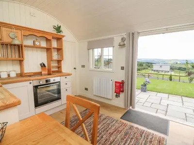 a kitchen with a table and a large window at Hillside View in Saint Harmon