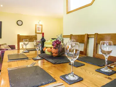 a wooden table with wine glasses and a bowl of fruit at Y Bwthyn in Llanegryn