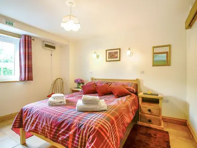 a bedroom with a bed with two towels on it at Y Bwthyn in Llanegryn