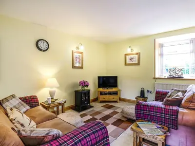 a living room with two couches and a tv at Y Bwthyn in Llanegryn
