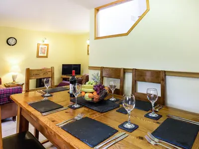 a wooden table with wine glasses and a bowl of fruit at Y Bwthyn in Llanegryn