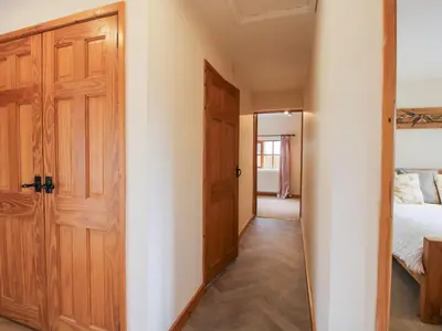 a room with a door and a bedroom with a bed at Old Hall Barn 1 in Church Stretton