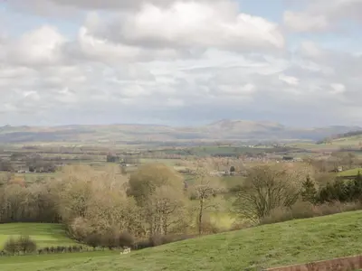 a view of a green field with hills in the background at Waggoners Cottage in Montgomery