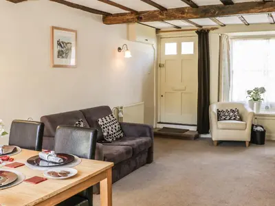 a living room with a couch and a table at Garden Cottage in Ludlow
