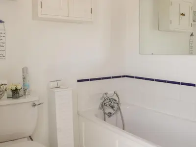 a white bathroom with a tub and a toilet at Garden Cottage in Ludlow