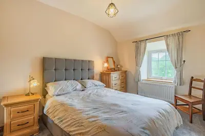 a bedroom with a bed and a chair and a window at Gwrtheyrn in Dyffryn