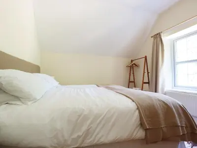 a white bed in a room with a window at School House in Builth Wells