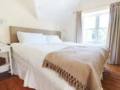 a white bed in a bedroom with a window at School House in Builth Wells