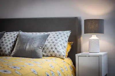 a bed with pillows and a lamp on a night stand at The Hall in Bucknell