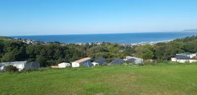 a group of houses on a hill next to the ocean at Dyfed 23 in Borth