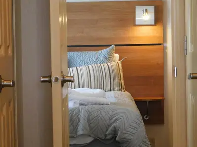 a bedroom with a bed with a wooden headboard at Dyfed 23 in Borth
