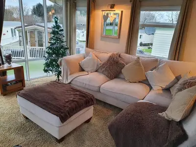 a living room with a couch and a christmas tree at Dyfed 23 in Borth