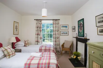 a bedroom with two beds and a window at The Old House, Llwyn Madoc in Llanwrtyd Wells