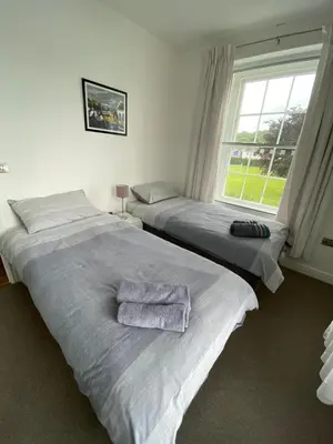 two twin beds in a room with a window at 2 Yr Hen Fanc in Aberaeron