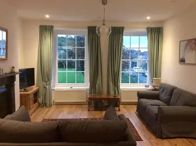a living room with a couch and two windows at 2 Yr Hen Fanc in Aberaeron