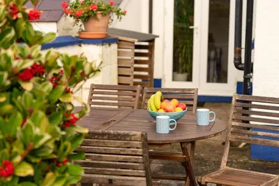 a wooden table with a bowl of fruit on it at Awelfryn in New Quay