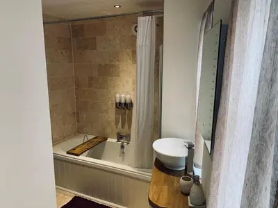 a bathroom with a sink and a bath tub with a sink at The Stowe in Shrewsbury