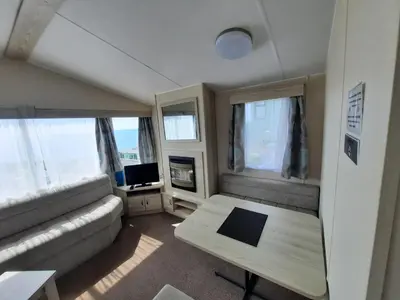 a small living room with a couch and a table at Hendre Coed Isaf Caravan Park in Barmouth