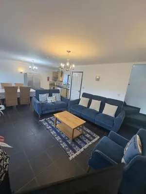 a living room with blue couches and a table at The Carthouse in Aberystwyth