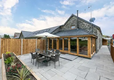 a patio with a table and chairs and a fence at 3 Bed in Bala oc-bow69 in Bala