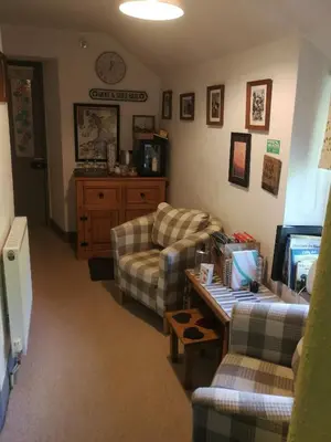 a living room with two couches and a table at Yr Hen Farcdy in Talsarnau