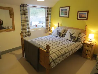 a bedroom with a bed and a window at Yr Hen Farcdy in Talsarnau