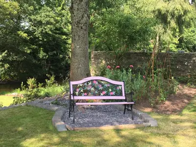 a bench sitting next to a tree in a garden at Brecon Boutique Breaks Wild Land in Sennybridge