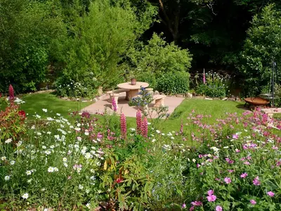a garden with a park bench and flowers at Brecon Boutique Breaks River Run in Sennybridge
