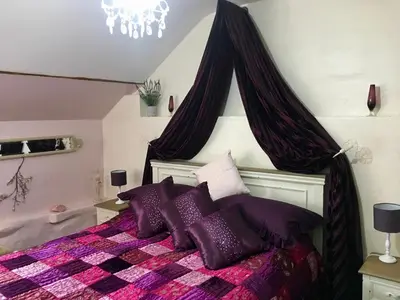 a bedroom with a bed with purple pillows at Brecon Boutique Breaks River Run in Sennybridge