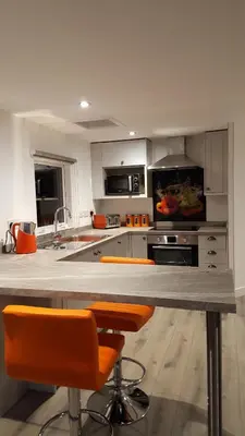 a kitchen with a counter and orange chairs in it at Ruth's Refresh Country Retreat with Private Hot Tub & Stunning Views in Shrewsbury