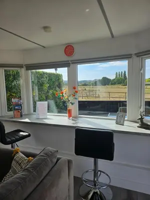 a living room with a couch and a large window at Ruth's Refresh Country Retreat with Private Hot Tub & Stunning Views in Shrewsbury