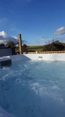a swimming pool filled with water next to a fence at Ruth's Refresh Country Retreat with Private Hot Tub & Stunning Views in Shrewsbury