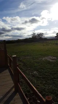a wooden boardwalk in a field with a fence at Ruth's Refresh Country Retreat with Private Hot Tub & Stunning Views in Shrewsbury