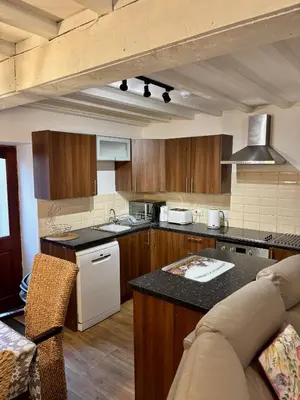 a kitchen with wooden cabinets and a counter top at The Workshop in Aberystwyth