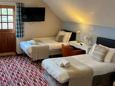 a hotel room with two beds and a television at The Workshop in Aberystwyth
