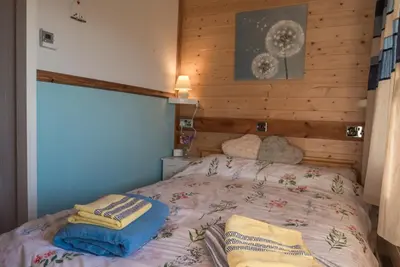 a bedroom with a bed with two towels on it at Enlli Fach cabin sleep's 2 adults and 2 children 2 dogs welcome not suitable for contract workers due to parking height restrictions in Borth