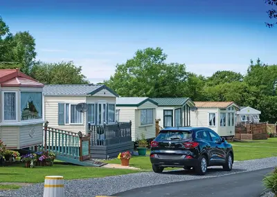 a car parked in front of a row of houses at The Village Holiday Park in New Quay
