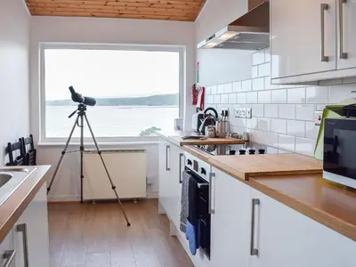 a camera on a tripod in a kitchen with a window at Seadrift in New Quay