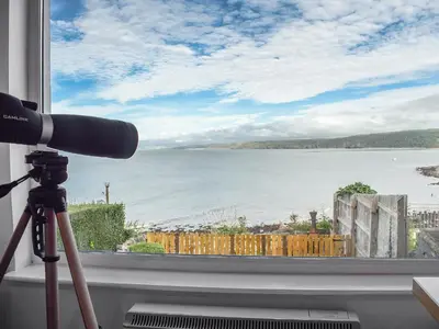 a camera and a view of the ocean from a window at Seadrift in New Quay
